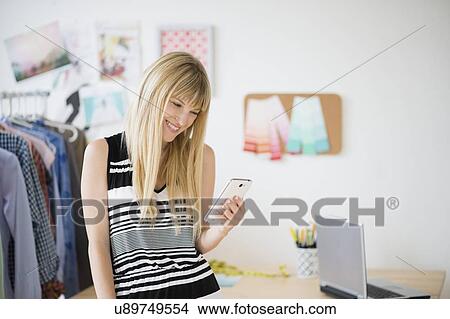 Woman looking at cell phone View Large Photo Image Picture - Woman looking at cell phone. Fotosearch