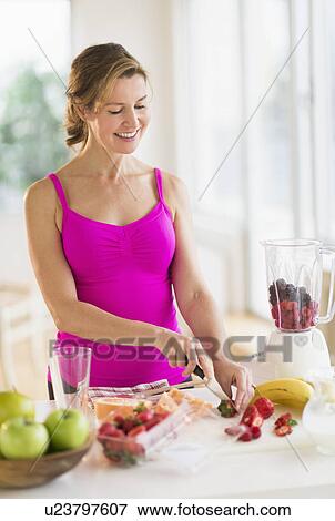 Woman preparing fruit drink View Large Photo Image Stock Photo - Woman preparing fruit drink. Fotosearch