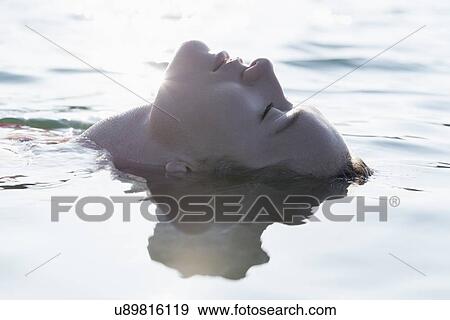 Stock Photo - Woman relaxing in lake. Fotosearch