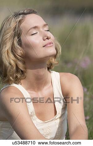 Stock Image - Woman relaxing on meadow. Fotosearch