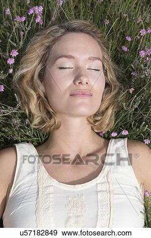 Woman relaxing on meadow View Large Photo Image Stock Photo - Woman relaxing on meadow. Fotosearch