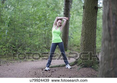 Woman stretching in forest View Large Photo Image Stock Photo - Woman stretching in forest. Fotosearch