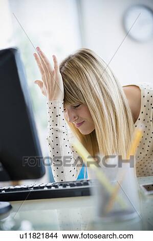 Woman suffering from headache in office View Large Photo Image Picture - Woman suffering from headache in office. Fotosearch