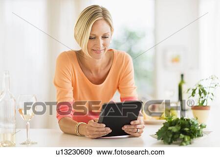 Woman using tablet pc at home View Large Photo Image Stock Photo - Woman using tablet pc at home. Fotosearch