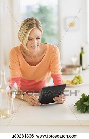 Woman using tablet pc at home View Large Photo Image Stock Photograph - Woman using tablet pc at home. Fotosearch