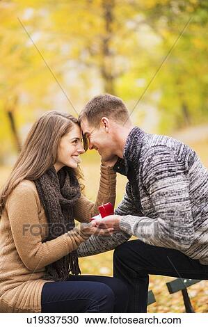 Stock Image - Young man proposing to young woman in Central Park. Fotosearch