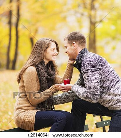 Stock Image - Young man proposing to young woman in Central Park. Fotosearch