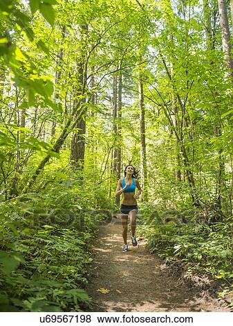 Young woman jogging in forest View Large Photo Image Stock Photo - Young woman jogging in forest. Fotosearch