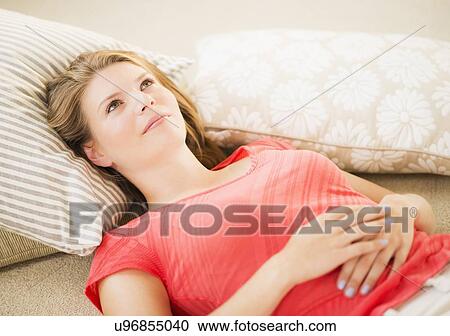 Young woman relaxing on floor View Large Photo Image Stock Image - Young woman relaxing on floor. Fotosearch