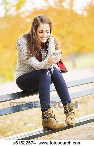 Young woman using cell phone in Central Park View Large Photo Image Picture - Young woman using cell phone in Central Park. Fotosearch