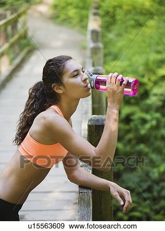 Young women resting, drinking water View Large Photo Image Stock Photo - Young women resting, drinking water. Fotosearch