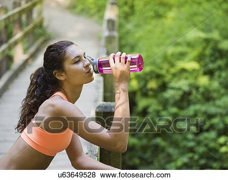 Young women resting, drinking water View Large Photo Image Stock Photo - Young women resting, drinking water. Fotosearch