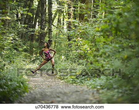 Young women stretching in forest View Large Photo Image Stock Photo - Young women stretching in forest. Fotosearch