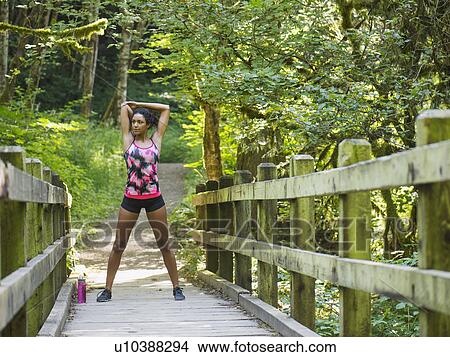 Picture - Young women stretching on footbridge. Fotosearch