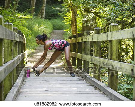 Young women stretching on footbridge View Large Photo Image Stock Image - Young women stretching on footbridge. Fotosearch