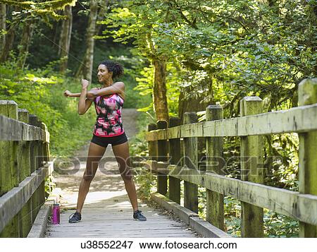 Young women stretching on footbridge View Large Photo Image Stock Photo - Young women stretching on footbridge. Fotosearch