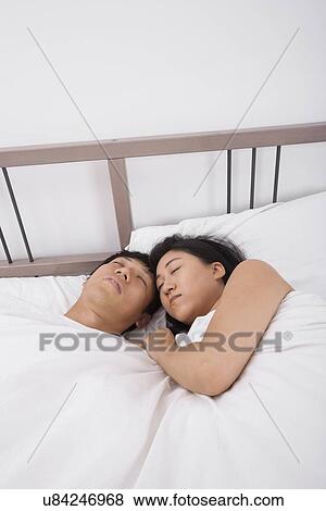 Asian couple sleeping in bed View Large Photo Image Stock Photo - Asian couple sleeping in bed. Fotosearch