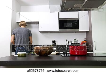 Back view of man standing in kitchen View Large Photo Image Stock Photography - Back view of man standing in kitchen. Fotosearch