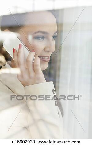 Beautiful businesswoman using cell phone in office View Large Photo Image Stock Image - Beautiful businesswoman using cell phone in office. Fotosearch