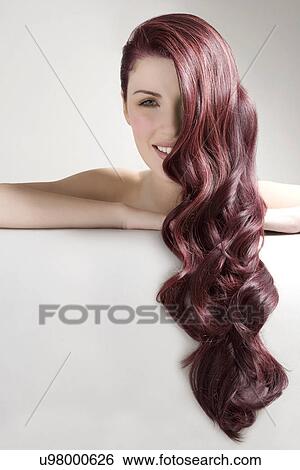 Beautiful woman with long red dyed hair against gray background View Large Photo Image Stock Photograph - Beautiful woman with long red dyed hair against gray background. Fotosearch
