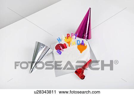 Birthday cake with party hats and noisemaker on table View Large Photo Image Stock Image - Birthday cake with party hats and noisemaker on table. Fotosearch