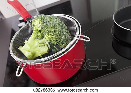 Stock Photography - Broccoli in saucepan on stove at kitchen. Fotosearch