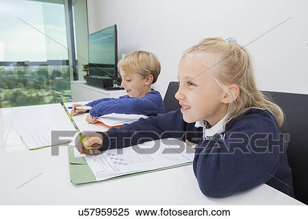Brother and sister doing homework at table in house View Large Photo Image Stock Photography - Brother and sister doing homework at table in house. Fotosearch