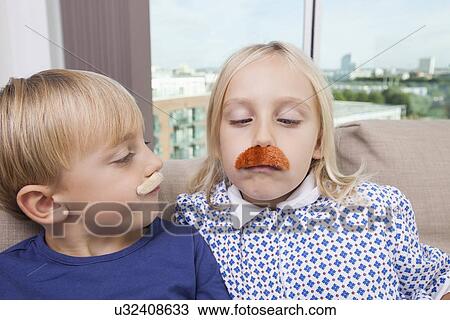 Brother and sister wearing artificial mustache at home View Large Photo Image Stock Image - Brother and sister wearing artificial mustache at home. Fotosearch