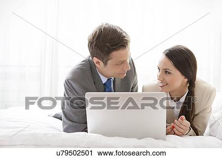 Business couple with laptop looking at each other in hotel room View Large Photo Image Stock Image - Business couple with laptop looking at each other in hotel room. Fotosearch