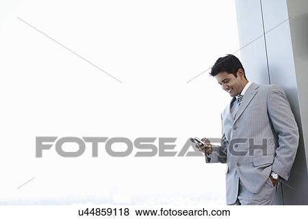 Business man using cell phone smiling View Large Photo Image Stock Photo - Business man using cell phone smiling. Fotosearch
