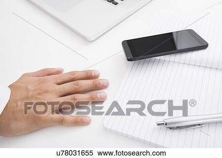 Businessman's hand on desk by cell phone, pen and book View Large Photo Image Stock Photography - Businessman's hand on desk by cell phone, pen and book. Fotosearch