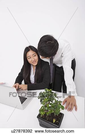 Businesspeople discussing over laptop at office desk View Large Photo Image Stock Image - Businesspeople discussing over laptop at office desk. Fotosearch