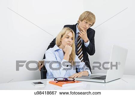 Stock Photo - Businesspeople working on laptop in office. Fotosearch