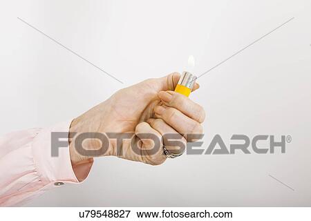 Businesswoman's hand holding cigarette lighter with flame in office View Large Photo Image Stock Photo - Businesswoman's hand holding cigarette lighter with flame in office. Fotosearch