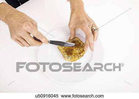Stock Photography - Businesswoman's hands spreading butter on bread. Fotosearch