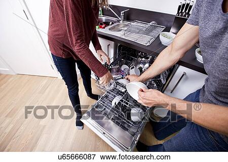 Caucasian couple loading dishwasher together in kitchen View Large Photo Image Stock Photo - Caucasian couple loading dishwasher together in kitchen. Fotosearch
