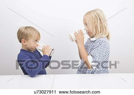 Children drinking milk while looking at each other View Large Photo Image Stock Image - Children drinking milk while looking at each other. Fotosearch