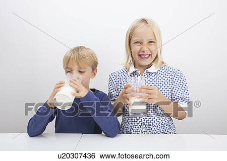 Children with glasses of milk at table View Large Photo Image Stock Photograph - Children with glasses of milk at table. Fotosearch