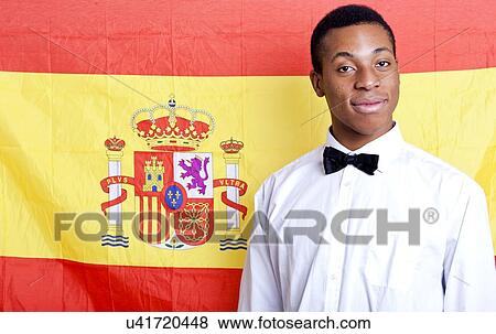 Stock Photo - Close-up portrait of young man against Spanish flag. Fotosearch