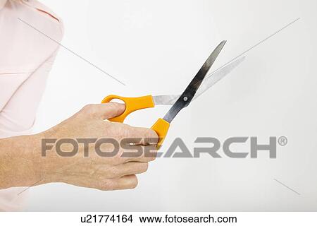 Picture - Close-up view of senior businesswoman holding scissors. Fotosearch