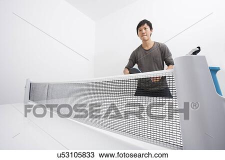 Stock Image - Confident mid adult man playing table tennis. Fotosearch