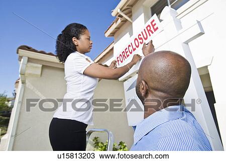 Couple putting up notice outside house View Large Photo Image Stock Image - Couple putting up notice outside house. Fotosearch
