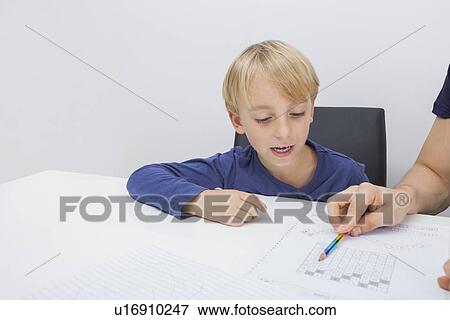 Stock Photo - Cropped image of father assisting boy in studies. Fotosearch