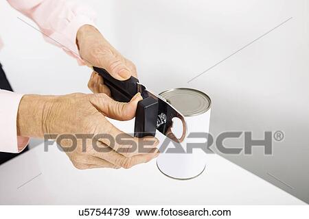 Cropped image of senior businesswoman opening canned food at office View Large Photo Image Stock Photo - Cropped image of senior businesswoman opening canned food at office. Fotosearch