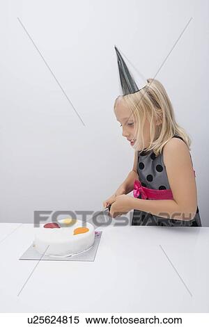 Cute girl cutting birthday cake at table in house View Large Photo Image Stock Photography - Cute girl cutting birthday cake at table in house. Fotosearch