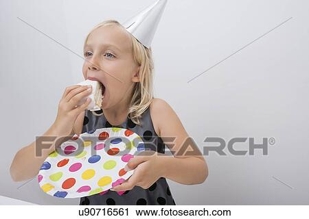 Cute girl eating birthday cake slice at home View Large Photo Image Stock Image - Cute girl eating birthday cake slice at home. Fotosearch