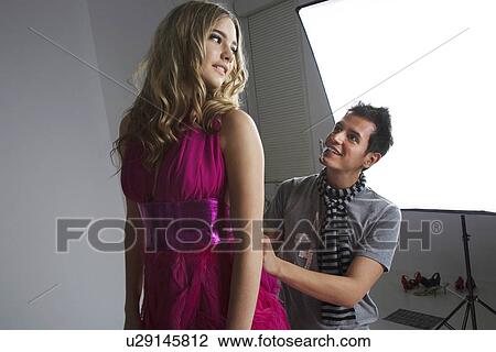 Designer adjusting fashion model's dress in studio View Large Photo Image Stock Image - Designer adjusting fashion model's dress in studio. Fotosearch