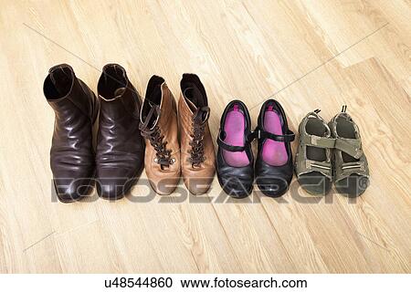 Family shoes placed in a row on hardwood floor View Large Photo Image Stock Image - Family shoes placed in a row on hardwood floor. Fotosearch