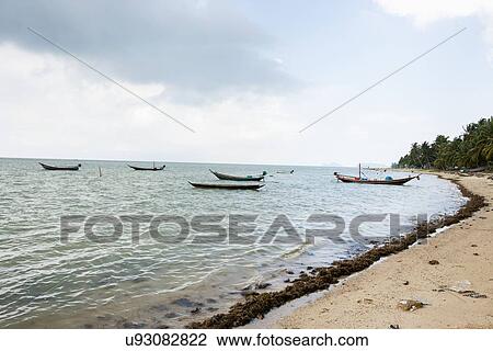 Stock Image - Fishing boats on shore, Koh Pha Ngan, Thailand. Fotosearch