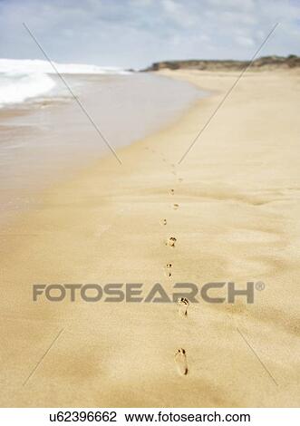 Stock Image - Footprints on sand at beach. Fotosearch
